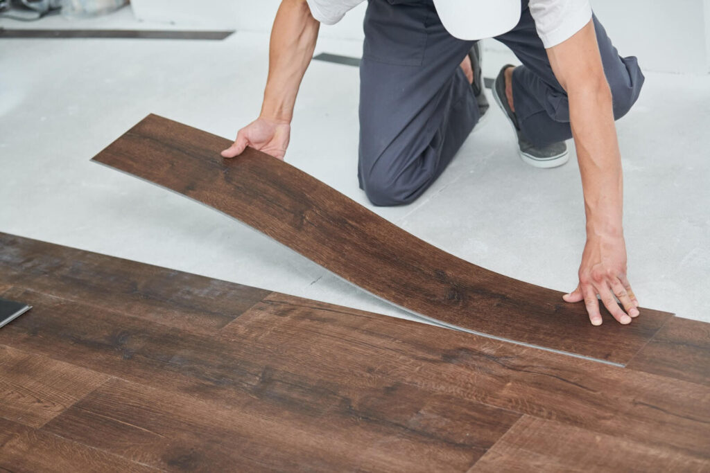 A worker installing hardwood flooring.